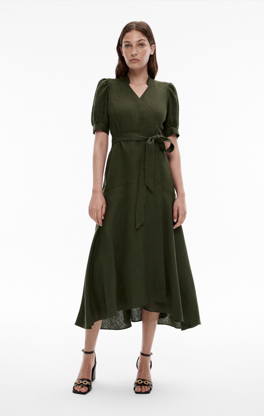 Woman in green short sleeve midi dress and black leather heels