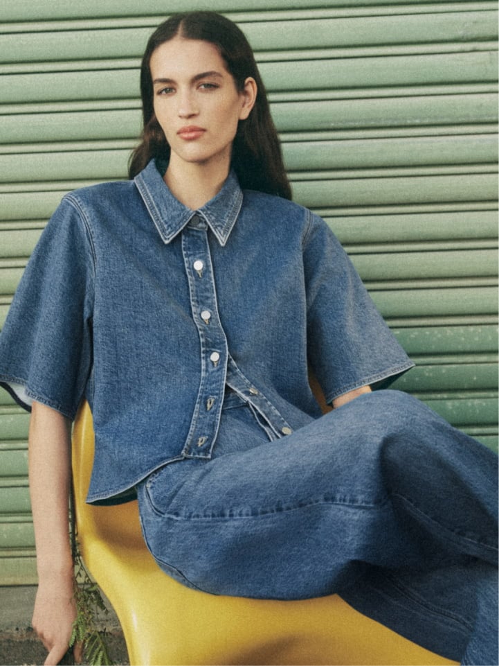 Woman wearing the indigo denim short sleeve shirt and indigo denim slouch jean