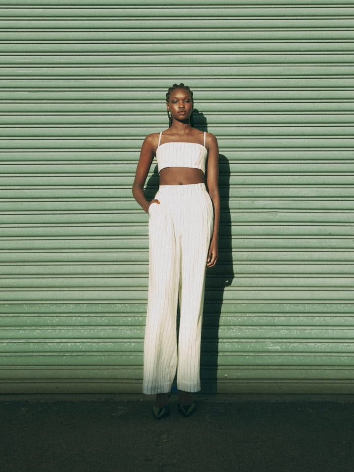 Woman wearing the blanc stripe crop bodice, blanc stripe linen pant and black scarlett mules