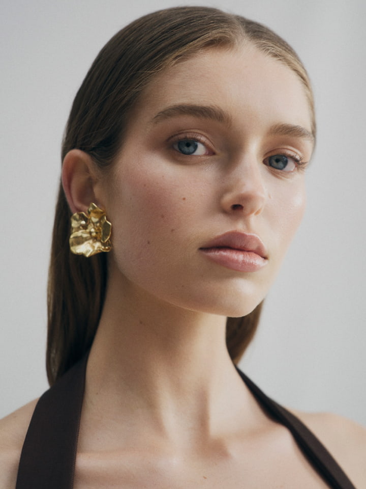 Woman in brown halter bustier and gold skye clip on earrings