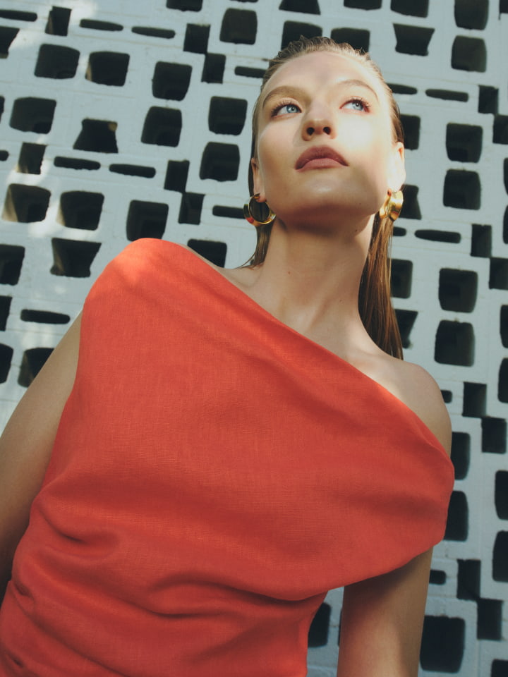 Woman in tangerine off shoulder mini dress