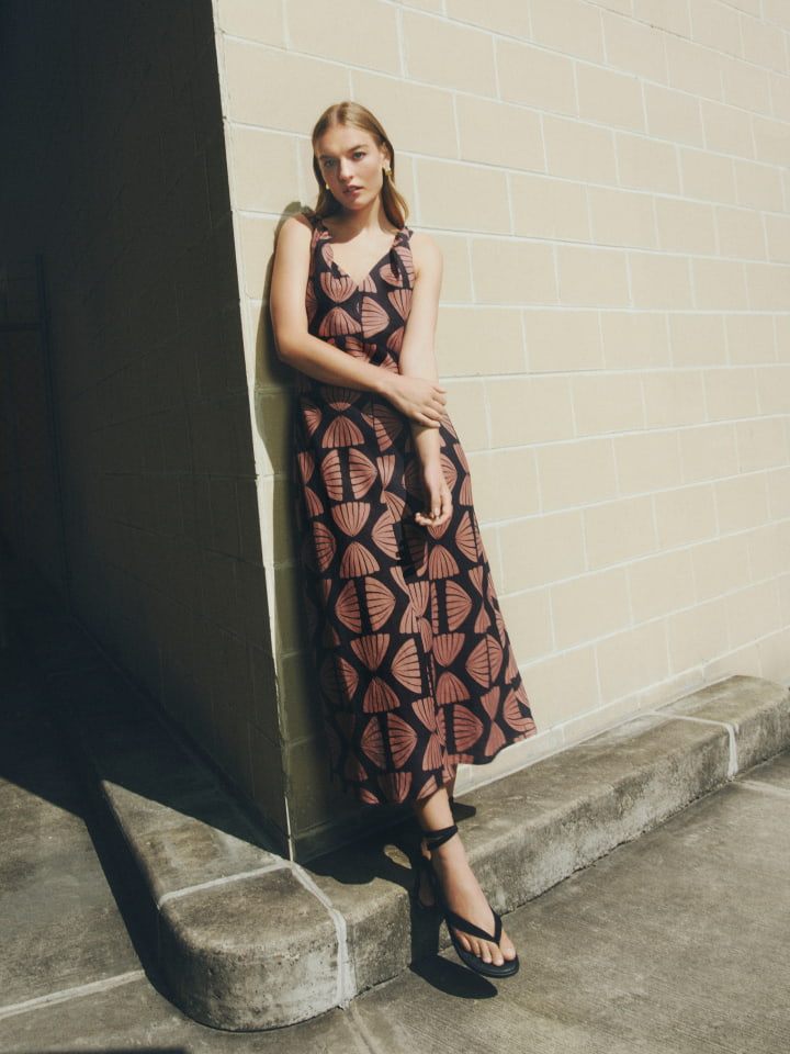 Woman in nutmeg print twist strap midi dress and black jade sandal