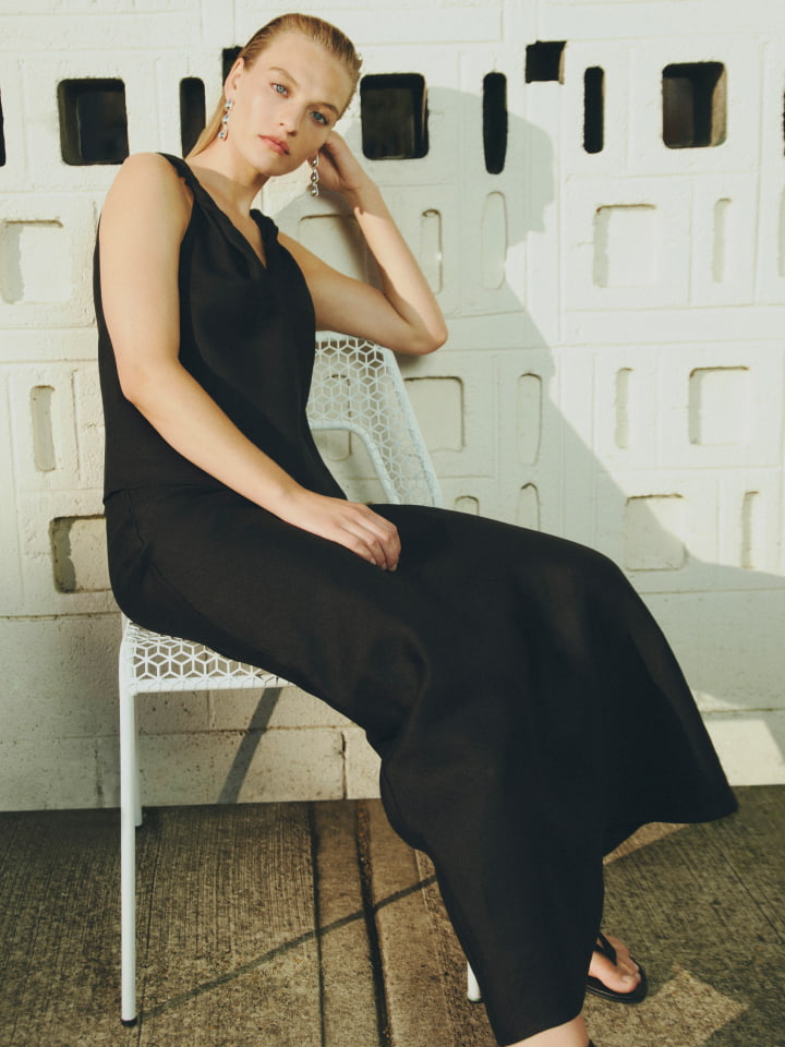 Woman in black twist strap camisole, black bias linen skirt, black jade sandal and silver zahra drop earring