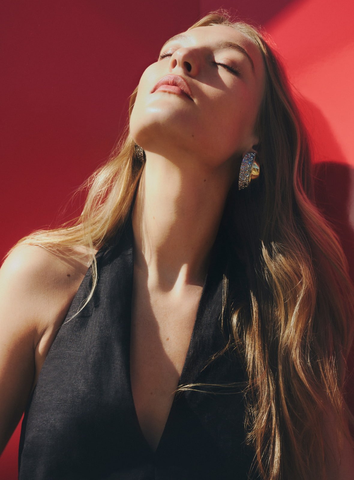 Woman in black halter jumpsuit and mixed metal bria clip on earring