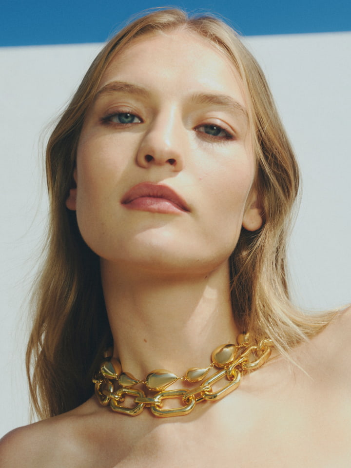 Woman in gold zahra necklace and gold elliot large necklace